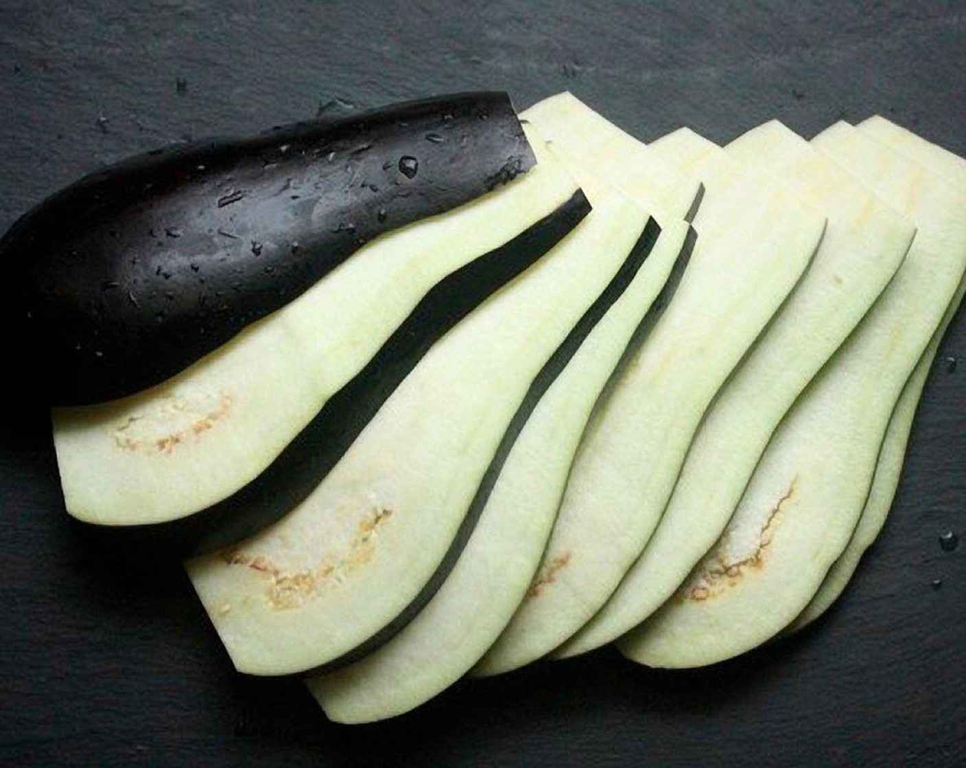 step 1 Remove the top and bottom of the Eggplant (1) and stand it up on a cutting board. Slice the eggplant length-wise as thinly as you can.